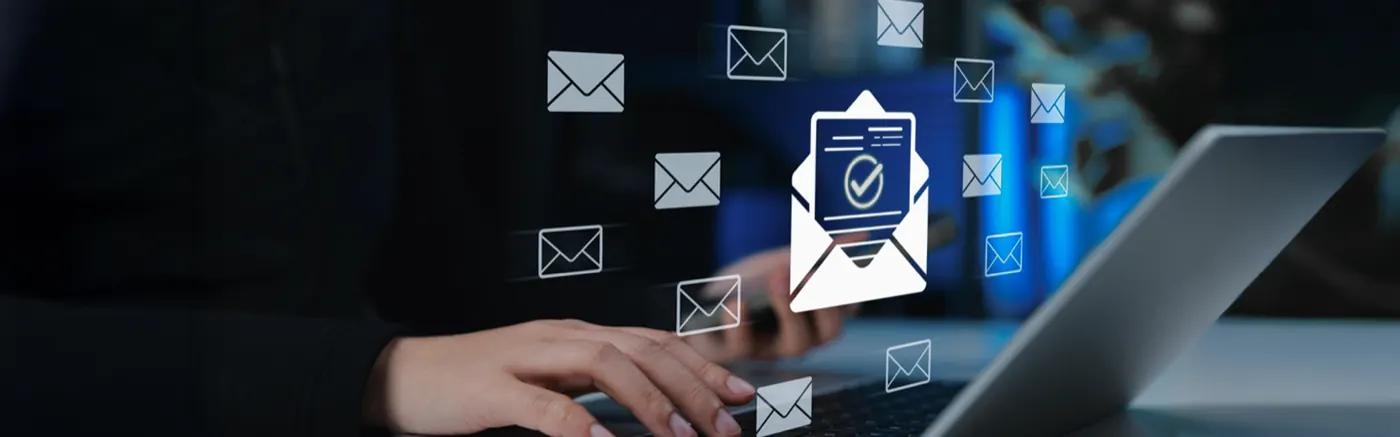 Hand on laptop with floating email icons — business email management by Aligned Tech